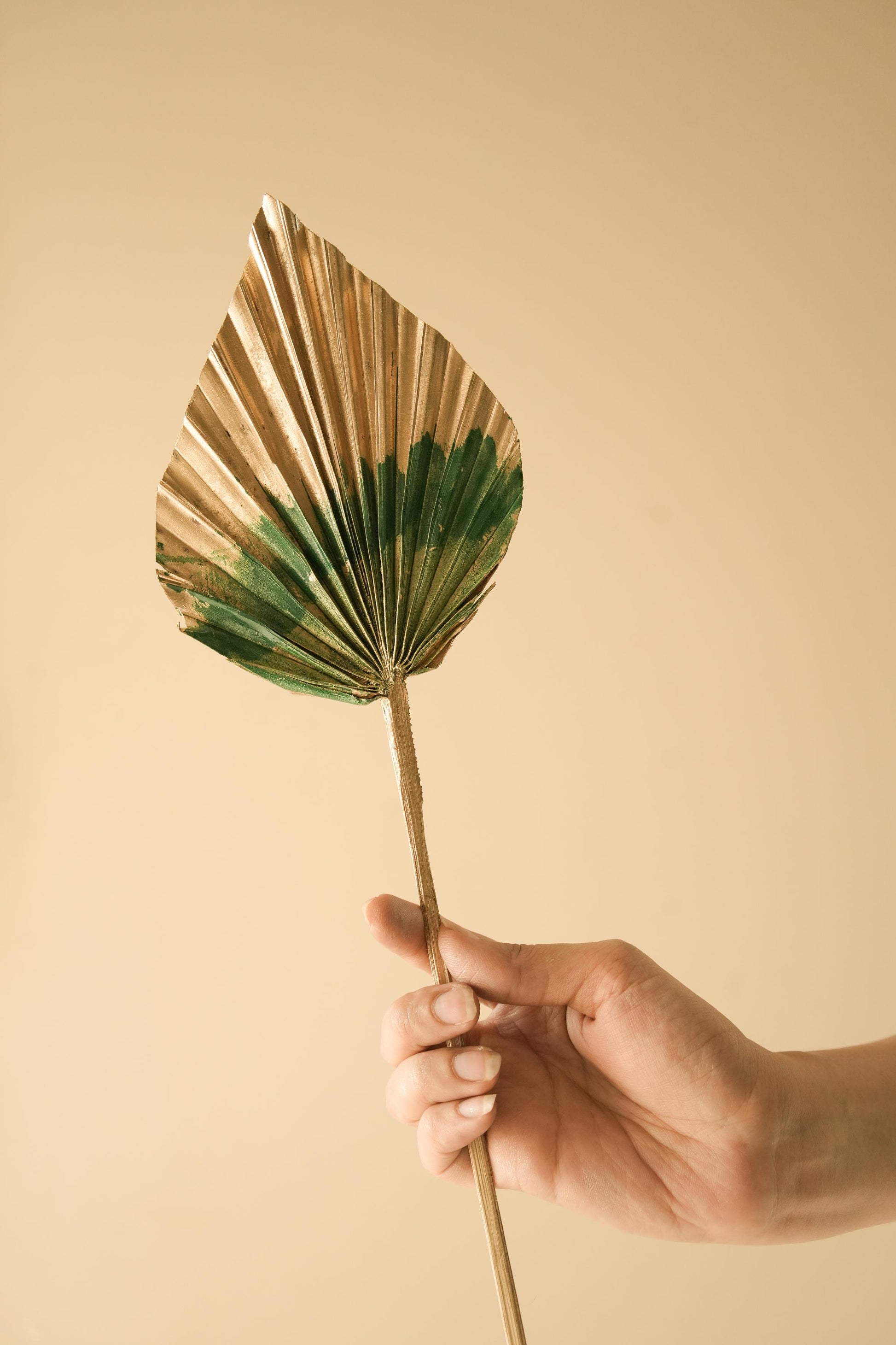 Luxury golden and green dual tone palm leaves arranged in a vase for elegant home decor setup
