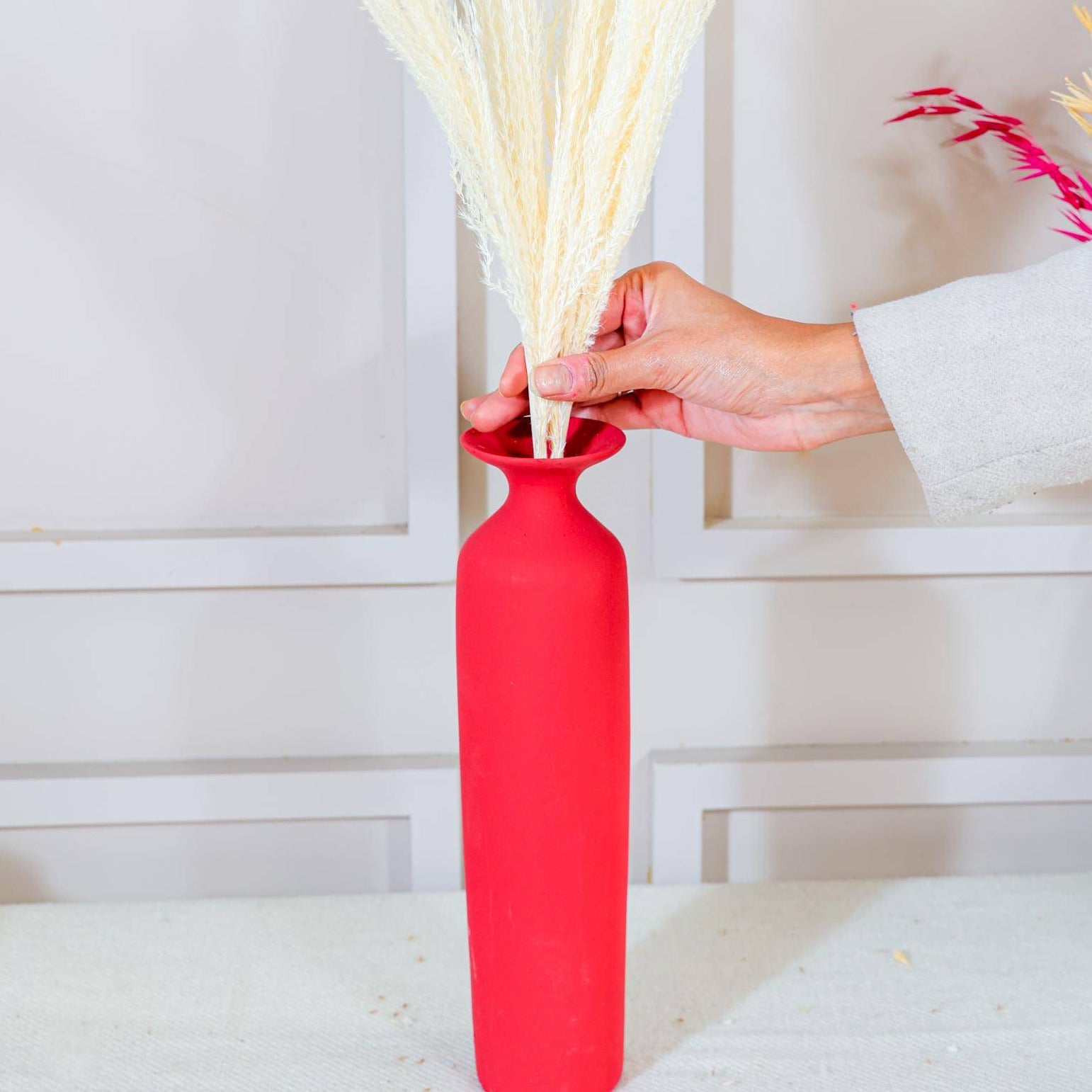 Red long vase with white reed pampas